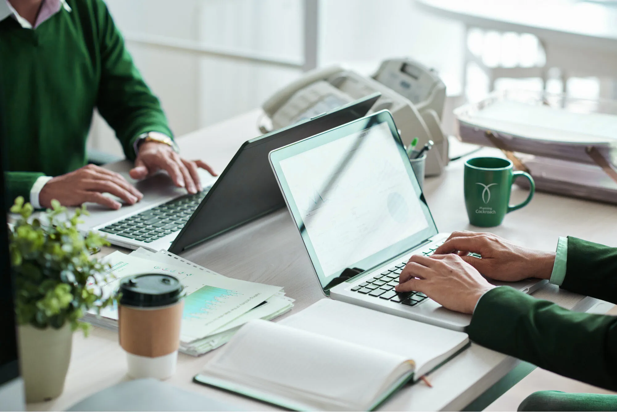 A team working on laptops with Planning Cockroach branding
